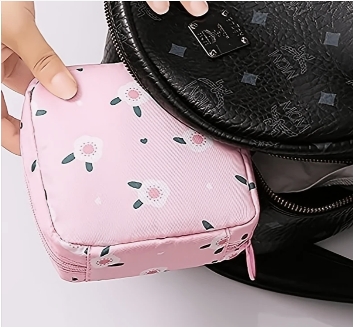 Pink storage pouch held by a hand next to a black textured bag.