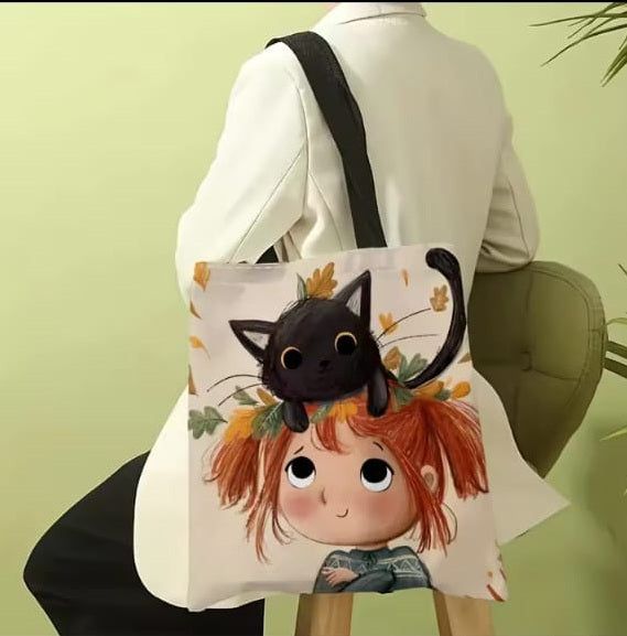 Person holding a tote bag with a black cat and girl design against a light green background